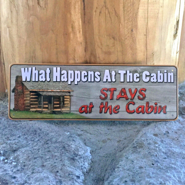 "What happens at the cabin stays at the cabin" tin metal sign.