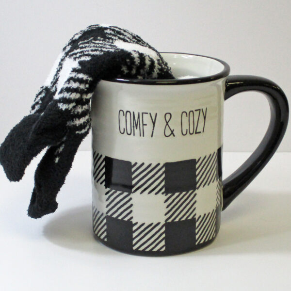 White and black plaid mug with comfy & cozy written on it.