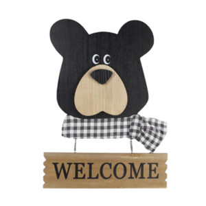 Wooden bear head with white and plaid scarf and welcome sign below.